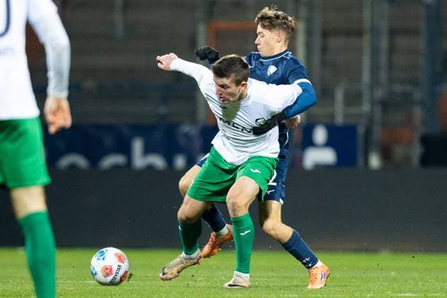23.11.2025, xkwix, Fußball, Regionalliga West, VfL Bochum 1848 U21, U 21 - FC Gütersloh, Vonovia Ruhrstadion: Kacper Koscierski (VfL Bochum U21 2) im Zweikampf gegen Aleksandar Kandic (FC Gütersloh 27) NRW Deutschland