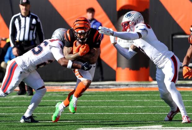 Cincinnati Bengals half back Chase Brown (30) is tackled by New England Patriots Carlton Davis (7) during the first half of play at Paycor Stadium on Sunday, November 23, 2025 in Cincinnati, Ohio.  KYP20251123001 JOHNxSOMMERSxII