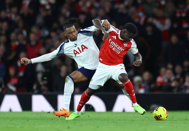 Destiny Udogie of Tottenham Hotspur competes for the ball with Bukayo Saka of Arsenal Arsenal v Tottenham Hotspur, Premier League, Football, Emirates Stadium, London, UK - 23 Nov 2025London Emirates Stadium United Kingdom EDITORIAL USE ONLY No use with unauthorised audio, video, data, fixture lists, club league logos or live services. Online in-match use limited to 120 images, no video emulation. No use in betting, games or single club league player publications. Copyright: xMichaelxZemanek Shutterstockx 15860967cz
