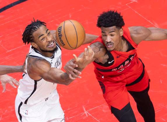 (251124) -- TORONTO, Nov. 24, 2025 -- Ochai Agbaji (R) of Toronto Raptors vies with Nic Claxton of Brooklyn Nets during the 2025-2026 NBA, Basketball Herren, USA regular season game between Toronto Raptors and Brooklyn Nets in Toronto, Canada, on Nov. 23, 2025. (Photo by Xinhua) (SP)CANADA-TORONTO-BASKETBALL-NBA-NETS VS RAPTORS ZouxZheng 