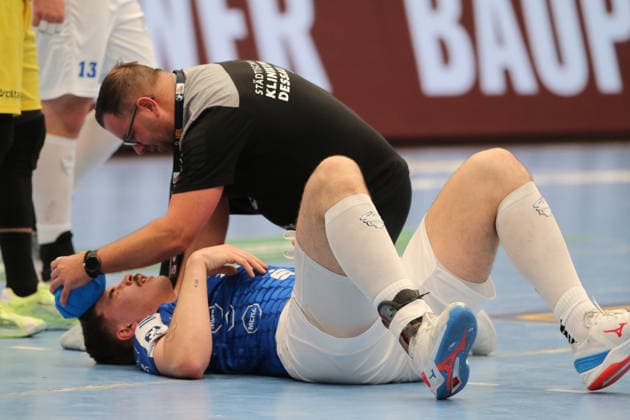 24.11.2025 Handball Herren 2025 2026 2. Bundesliga 12. Spieltag Dessau-Roßlauer HV 06 - VfL Eintracht Hagen Anhalt Arena Dessau Marcel Nowak (DRHV, blau) wird von Ive Lassanske (DRHV, Physio) nach einem Foulspiel behandelt. Dessau-Roßlau Sachsen-Anhalt Deutschland