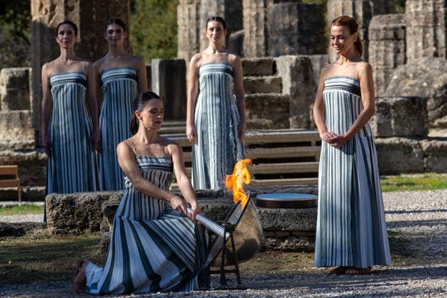 (251126) -- ANCIENT OLYMPIA, Nov. 26, 2025 -- Actress Mary Mina (front), in the role of an ancient Greek High Priestess, lights the flame during the dress rehearsal of the Olympic flame lighting ceremony for the Milan-Cortina 2026 Winter Olympic Games, Olympische Spiele, Olympia, OS in Ancient Olympia, Greece, on Nov. 24, 2025. (Photo by Xinhua) (SP)GREECE-ANCIENT OLYMPIA-MILAN-CORTINA 2026-FLAME LIGHTING CEREMONY MariosxLolos 