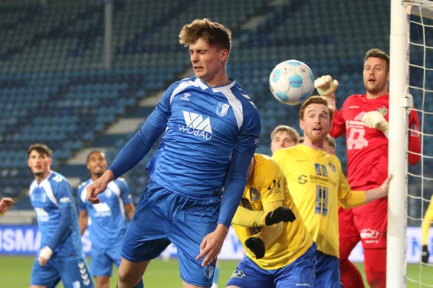 26.11.2025 Fußball Herren 2025 2026 Regionalliga Nordost 17. Spieltag 1. FC Magdeburg - 1. FC Lokomotive Leipzig Avnet Arena Magdeburg Magnus Baars (FCM, blau) verpasst einen Eckball. Lukas Wilton (LOK, gelb) und Andreas Naumann (LOK, rot) stehen am kurzen Pfosten bereit. Magdeburg Sachsen-Anhalt Deutschland