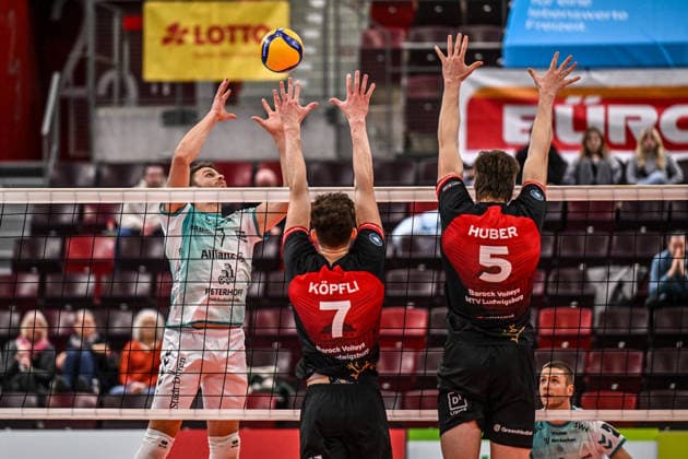 DVV-Pokal MTV Ludwigsburg - SWD powervolleys Dueren 26.11.2025 DVV_Pokal, Volleyball, 1. Bundesliga, Herren, Saison 2025 26, Viertelfinale, Barock Volleys MTV Ludwigsburg (in Rot-Schwarz) vs SWD powervolleys Dueren (in Weiss-Gruen), Jordan Alexander Canham links, pritscht übers Netz, 7 Tim Köpfli und 5 Jan Huber im Block, Copyright: xBEAUTIFULxSPORTS TomxBlochx