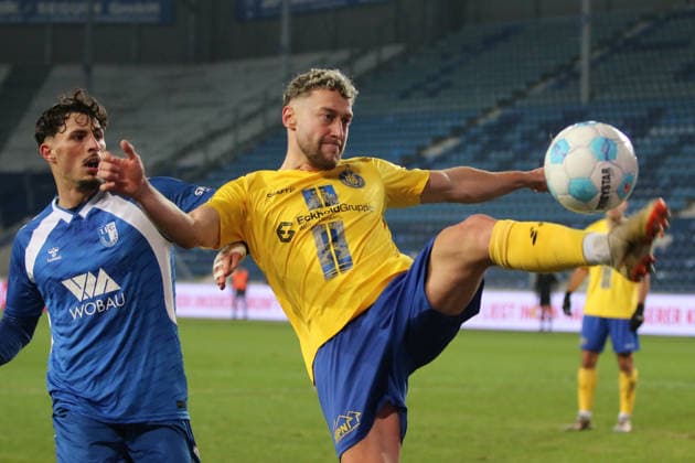 26.11.2025 Fußball Herren 2025 2026 Regionalliga Nordost 17. Spieltag 1. FC Magdeburg - 1. FC Lokomotive Leipzig Avnet Arena Magdeburg David Grözinger (LOK, gelb) klärt einen Ball vor Eldin Dzogovic (FCM, blau). Magdeburg Sachsen-Anhalt Deutschland