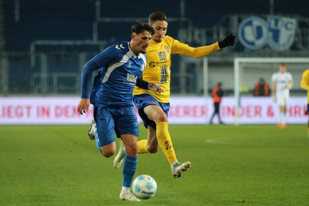 26.11.2025 Fußball Herren 2025 2026 Regionalliga Nordost 17. Spieltag 1. FC Magdeburg - 1. FC Lokomotive Leipzig Avnet Arena Magdeburg Eldin Dzogovic (FCM, blau) im Laufduell mit Alexander Siebeck (LOK, gelb). Magdeburg Sachsen-Anhalt Deutschland