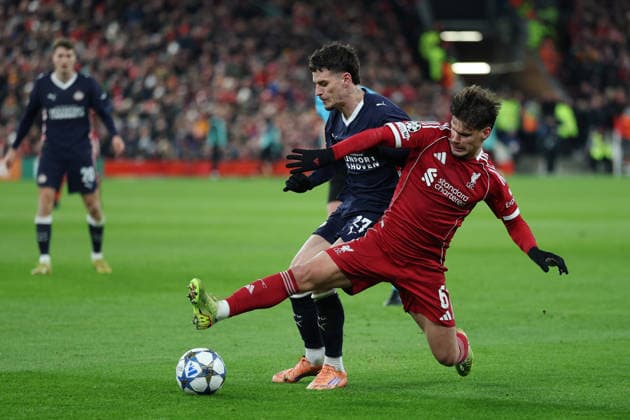 Liverpool, England, 26th November 2025. Dennis Man of PSV Eindhoven and Milos Kerkez of Liverpool challenge for the ball during the Liverpool vs PSV Eindhoven UEFA Champions League match at Anfield, Liverpool. Picture credit should read: James Baylis Sportimage EDITORIAL USE ONLY. No use with unauthorised audio, video, data, fixture lists, club league logos or live services. Online in-match use limited to 120 images, no video emulation. No use in betting, games or single club league player publications. SPI_054_JB_Liverpool_PSV SPI-4311-0054