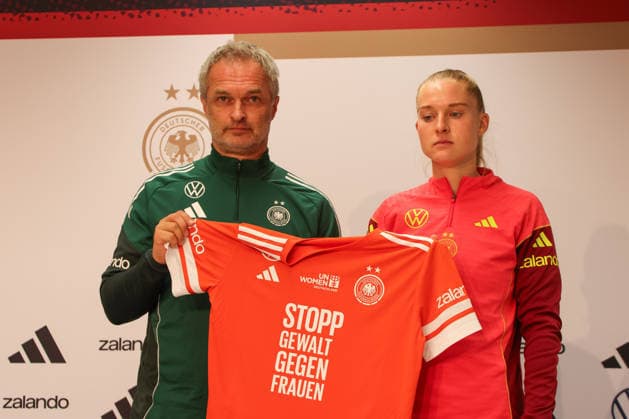 Kaiserslautern, Deutschland 27. November 2025: UEFA Nations League Women - Abschluss PK - 2025 - Deutschland vs. Spanien Im Bild: v.li. Bundestrainer Christian Wück Wueck (Deutschland) und Janina Minge (Deutschland) halten das Trikot zum Aktionstag Orange The World zur Bekämpfung von Gewalt gegen Frauen Fritz-Walter-Stadion Rheinland Pfalz Copyright: xFotostandx xFantinix