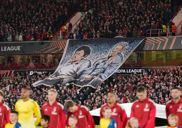 Nottingham, England, 27th November 2025. Former Nottingham Forest managership duo of Brian Clough and Peter Taylor are displayed on a giant flag during the Nottingham Forest vs Malmo UEFA Europa League match at the City Ground, Nottingham. Picture credit should read: Andrew Yates Sportimage EDITORIAL USE ONLY. No use with unauthorised audio, video, data, fixture lists, club league logos or live services. Online in-match use limited to 120 images, no video emulation. No use in betting, games or single club league player publications. SPI_018_AY_Forest_Malmo SPI-4328-0024