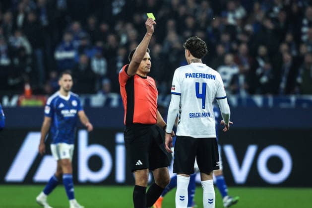 Fussball, 2. Bundesliga Saison 2025 2026 14. Spieltag FC Schalke 04 - SC Paderborn 07 28.11.2025, VELTINS-Arena Tobias Reichel (Schiedsrichter) gibt Calvin Brackelmann (SC Paderborn, 4) nach VAR Sichtung die Gelbe Karte Gelsenkirchen VELTINS-Arena Nordrhein-Westfalen Deutschland