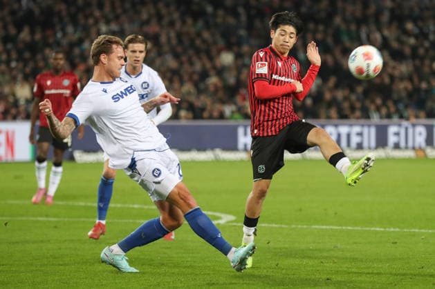 28.11.2025, xtgx, Fussball - 2.Bundesliga Hannover 96 - Karlsruher SC emspor, v.l. David Herold (Karlsruhe, 20), Daisuke Yokota (Hannover, 18) Zweikampf, Duell, Kampf, tackle (DFL DFB REGULATIONS PROHIBIT ANY USE OF PHOTOGRAPHS as IMAGE SEQUENCES and or QUASI-VIDEO) Hannover