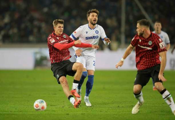 Foto : Maik Nawrocki (H 96) kommt zu Fall gegen Fabian Schleusener (KSC) Fussball 2. Liga , 14. Spieltag am Fr. 28.11.2025 Hannover 96 - Karlsruher SC