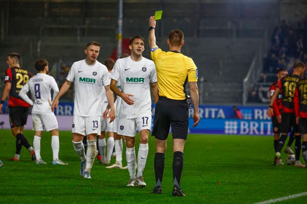 28.11.2025, xavx, Fussball 3.Liga, SV Wehen Wiesbaden - Erzgebirge Aue v.l. Referee Schiedsrichter Kevin Behrens zeigt die Gelbe Karte fuer, shows yellow card to Pascal Fallmann (FC Erzgebirge Aue) (DFL DFB REGULATIONS PROHIBIT ANY USE OF PHOTOGRAPHS as IMAGE SEQUENCES and or QUASI-VIDEO) Wiesbaden