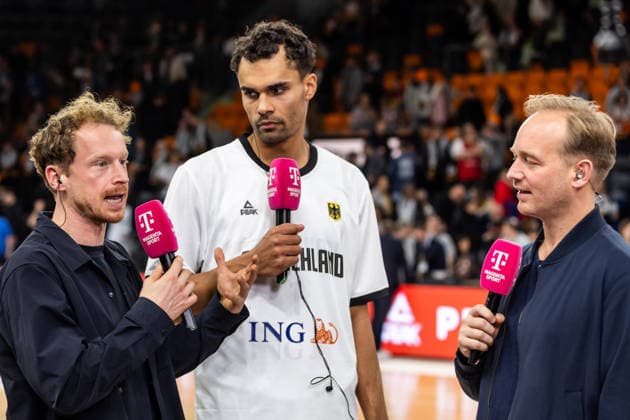 GER, FIBA Basketball World Cup 2027, European Qualifiers, Deutschland-Israel. 28.11.2025, Ratiopharm Arena, Neu-Ulm, GER, FIBA Basketball World Cup 2027, European Qualifiers, Deutschland-Israel. Oscar da Silva (Deutschland, No1) im Interview mit Peer Günther und Jan Lüdeke (Magenta  Foto: Alexander Trienitz Neu-Ulm Ratiopharm Arena Bayern Deutschland