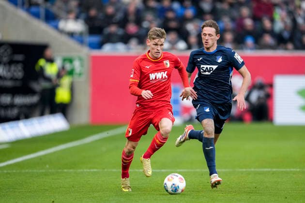 v.li.: Anton Kade (FCA, 30), Wouter Burger (Hoffenheim, 18), Zweikampf, Spielszene, Duell, duel, tackle, tackling, Dynamik, Action, Aktion, 29.11.2025, Sinsheim (Deutschland), Fussball, Bundesliga, TSG 1899 Hoffenheim - FC Augsburg, DFB DFL REGULATIONS PROHIBIT ANY USE OF PHOTOGRAPHS AS IMAGE SEQUENCES AND OR QUASI-VIDEO.
