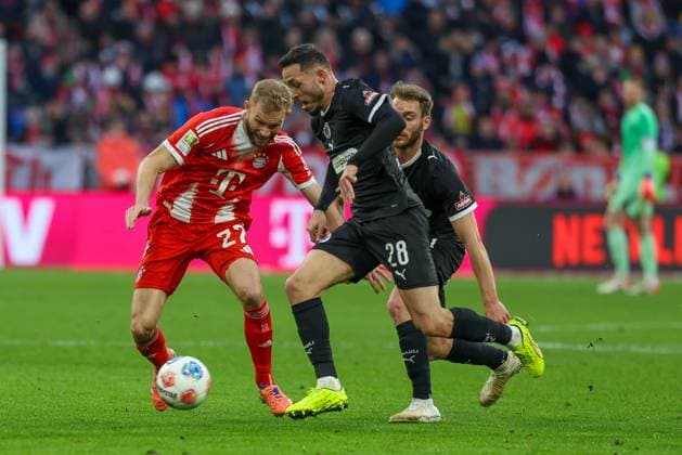 im Zweikampf, Aktion, mit Konrad Laimer 27 (FC Bayern Muenchen), Mathias Pereira Lage 28 (FC St. Pauli), FC Bayern Muenchen vs. FC St. Pauli, Fussball, 1. Bundesliga, 12. Spieltag, 29.11.2025 DFB regulations prohibit any use of photographs as image sequences and or quasi-video Muenchen Bayern Deutschland