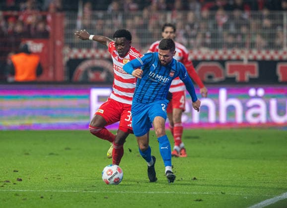 Fußball, Herren, Saison 2025 2026, 1. Bundesliga (12. Spieltag), 1. FC Union Berlin - 1. FC Heidenheim, v. l. Derrick Köhn (1. FC Union Berlin), Marnon Busch (Heidenheim), 29.11.2025, Copyright: xSebastianxRäppold MatthiasxKochx