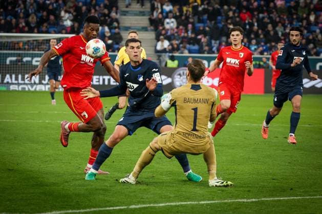 Samuel Essende 9 (FC Augsburg) mit einer Chance, gegen Robin Hranac 2 (TSG 1899 Hoffenheim) und Oliver Baumann 1 (TSG 1899 Hoffenheim), TSG Hoffenheim vs. FC Augsburg, Fussball, Bundesliga, DFL, Saison 2025 2026, Hinrunde, 12. Spieltag, 29.11.2025 DFB regulations prohibit any use of photographs as image sequences and or quasi-video Sinsheim Baden-Wuerttemberg Deutschland