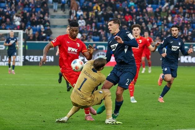Samuel Essende 9 (FC Augsburg) mit einer Chance, gegen Robin Hranac 2 (TSG 1899 Hoffenheim) und Oliver Baumann 1 (TSG 1899 Hoffenheim), TSG Hoffenheim vs. FC Augsburg, Fussball, Bundesliga, DFL, Saison 2025 2026, Hinrunde, 12. Spieltag, 29.11.2025 DFB regulations prohibit any use of photographs as image sequences and or quasi-video Sinsheim Baden-Wuerttemberg Deutschland