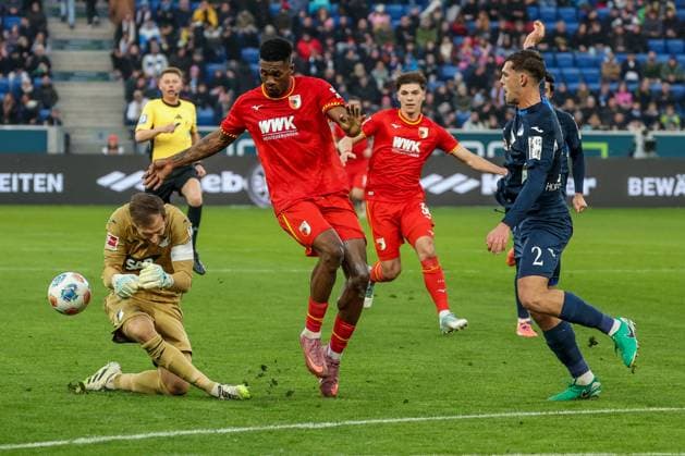 Samuel Essende 9 (FC Augsburg) mit einer Chance, gegen Robin Hranac 2 (TSG 1899 Hoffenheim) und Oliver Baumann 1 (TSG 1899 Hoffenheim), TSG Hoffenheim vs. FC Augsburg, Fussball, Bundesliga, DFL, Saison 2025 2026, Hinrunde, 12. Spieltag, 29.11.2025 DFB regulations prohibit any use of photographs as image sequences and or quasi-video Sinsheim Baden-Wuerttemberg Deutschland