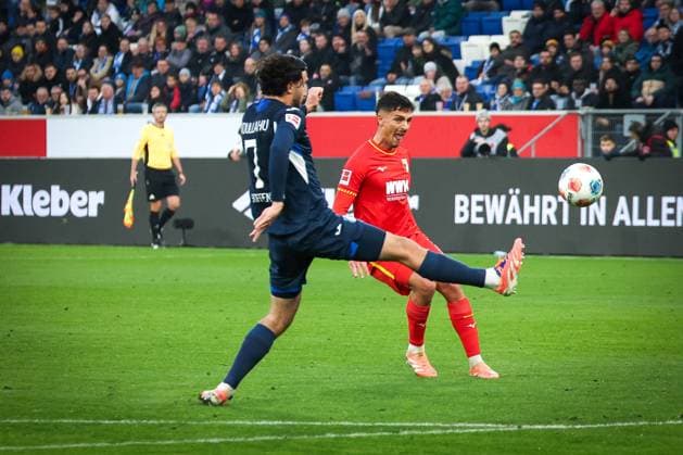 Dimitris Giannoulis 13 (FC Augsburg) versucht einen Heber, der das Tor verfehlt, mit Leon Avdullahu 7 (TSG 1899 Hoffenheim), TSG Hoffenheim vs. FC Augsburg, Fussball, Bundesliga, DFL, Saison 2025 2026, Hinrunde, 12. Spieltag, 29.11.2025 DFB regulations prohibit any use of photographs as image sequences and or quasi-video Sinsheim Baden-Wuerttemberg Deutschland