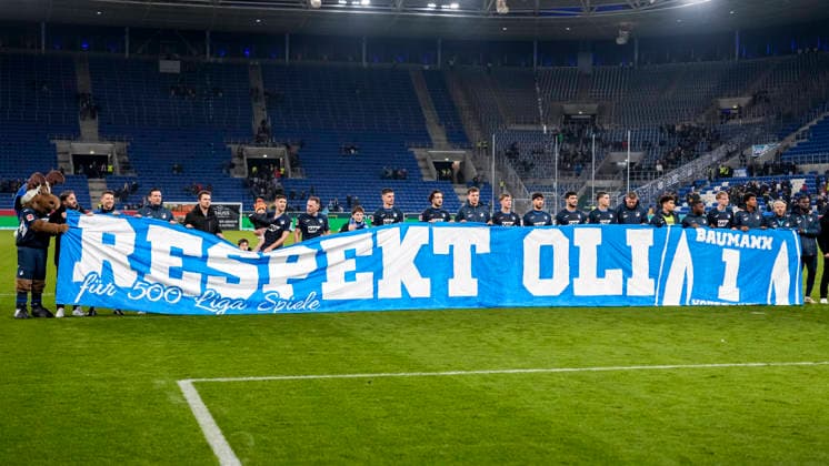 Spieler der TSG 1899 Hoffenheim halten ein Banner für Oliver Baumann (Torwart, Hoffenheim, 1, nicht im Bild), Aufschrift: Respekt Olli für 500 Liga Spiele, 29.11.2025, Sinsheim (Deutschland), Fussball, Bundesliga, TSG 1899 Hoffenheim - FC Augsburg, DFB DFL REGULATIONS PROHIBIT ANY USE OF PHOTOGRAPHS AS IMAGE SEQUENCES AND OR QUASI-VIDEO.