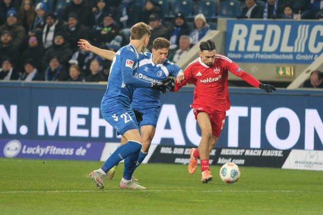 29.11.2025 Fußball Herren 2025 2026 2. Bundesliga 14. Spieltag 1. FC Magdeburg - 1. FC Nürnberg Avnet Arena Magdeburg Berkay Yilmaz (FCN, rot) im Zweikampf mit Alexander Nollenberger (FCM, blau). Philipp Hercher (FCM, blau, 27) beobachtet die Situation. Magdeburg Sachsen-Anhalt Deutschland