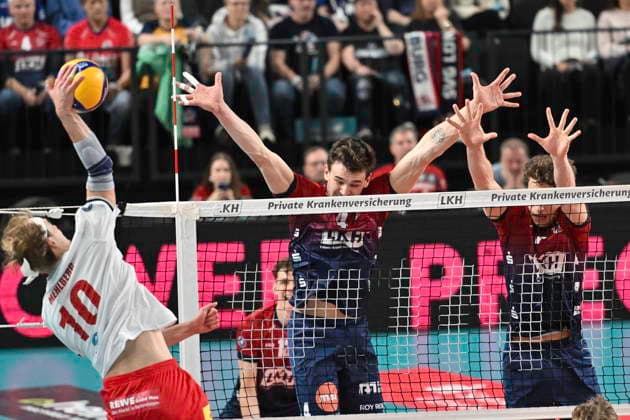 GER; 1.VBL, SVG Lueneburg vs SV Warnemuende 29.11.2025, LKH Arena, Lueneburg, GER; 1. VBL, SVG Lueneburg vs SV Warnemuende im Bild Christopher Byam (Lueneburg 04) und Joscha Kunstmann (Lueneburg 07) versuchen sich gegen Tommy Mehlberg (Warnemuende 10) durchzusetzen