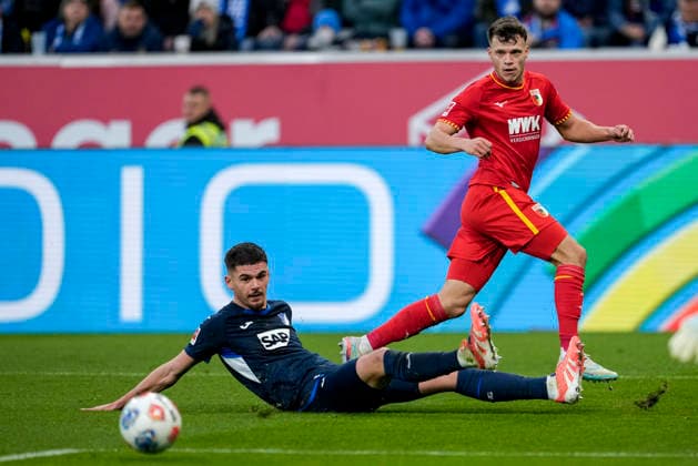 v.li.: Albian Hajdari (Hoffenheim, 21), Robin Fellhauer (FCA, 19), Zweikampf, Spielszene, Duell, duel, tackle, tackling, Dynamik, Action, Aktion, 29.11.2025, Sinsheim (Deutschland), Fussball, Bundesliga, TSG 1899 Hoffenheim - FC Augsburg, DFB DFL REGULATIONS PROHIBIT ANY USE OF PHOTOGRAPHS AS IMAGE SEQUENCES AND OR QUASI-VIDEO.