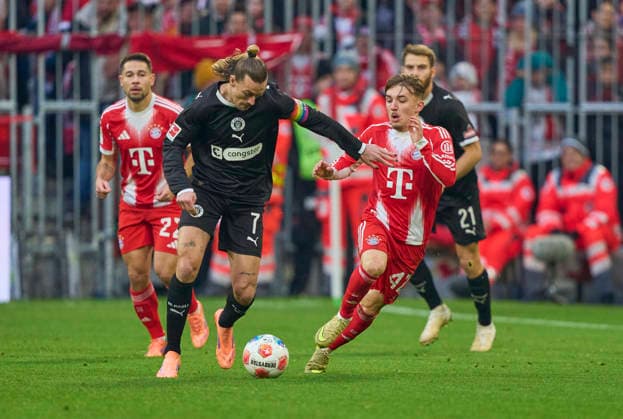 Lennart Karl of FC Bayern München compete for the ball, tackling, duel, header, zweikampf, action, fight against Jackson Irvine of St.Pauli in the match FC BAYERN MÜNCHEN - FC ST. PAULI 3-1 on November 29, 2025 at Allianz Arena München, Germany. Season 2026 2026, 1.Bundesliga, FCB, matchday 12,