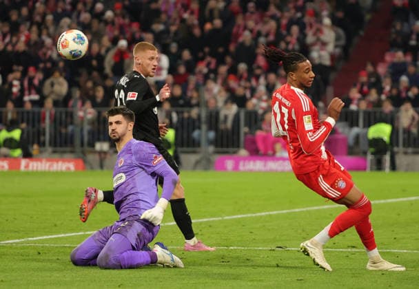 29.11.2025,1. Bundesliga, FC Bayern Muenchen vs St Pauli, Allianz Arena Muenchen, Fussball, im Bild: Lars Ritzka (St Pauli), Nikola Vasilj (St Pauli) stoppen Michael Olise (FC Bayern Muenchen)