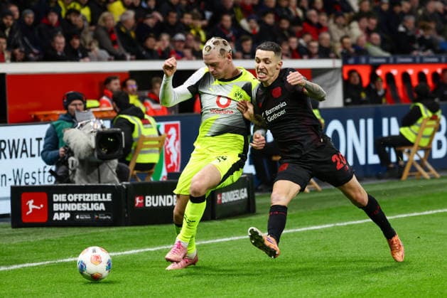 Leverkusen, BayArena, 29.11.25, GER, Herren, 1. Bundesliga, Saison 2025 - 2026, Bayer 04 Leverkusen - Borussia Dortmund, Julian Ryerson (Borussia Dortmund) und Alejandro Grimaldo (Bayer 04 Leverkusen) im Zweikampf, DFB DFL REGULATIONS PROHIBIT ANY USE OF PHOTOGRAPHS AS IMAGE SEQUENCES AND OR QUASI-VIDEO. Copyright: JoachimxBywaletz xJB-Sportfoto