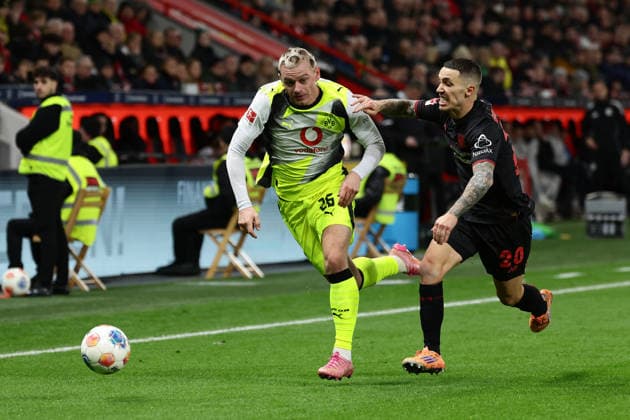 Leverkusen, BayArena, 29.11.25, GER, Herren, 1. Bundesliga, Saison 2025 - 2026, Bayer 04 Leverkusen - Borussia Dortmund, Julian Ryerson (Borussia Dortmund) und Alejandro Grimaldo (Bayer 04 Leverkusen) im Zweikampf, DFB DFL REGULATIONS PROHIBIT ANY USE OF PHOTOGRAPHS AS IMAGE SEQUENCES AND OR QUASI-VIDEO. Copyright: JoachimxBywaletz xJB-Sportfoto