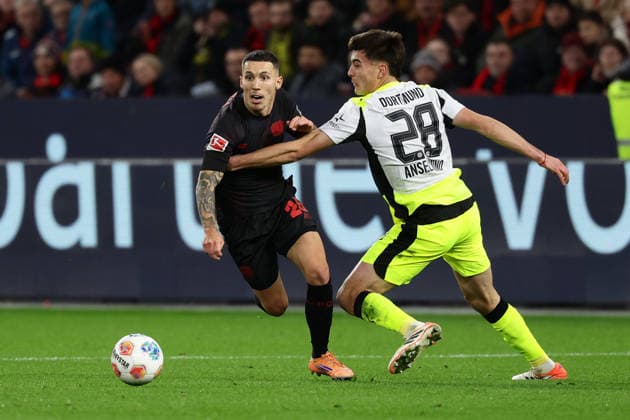 (251130) -- LEVERKUSEN, Nov. 30, 2025 -- Alejandro Grimaldo (L) of Bayer 04 Leverkusen vies with Aaron Anselmino of Borussia Dortmund during the German first division of Bundesliga football match between Bayer 04 Leverkusen and Borussia Dortmund in Leverkusen, Germany, Nov. 29. 2025. (Photo by Xinhua) (SP)GERMANY-LEVERKUSEN-FOOTBALL-BUNDESLIGA-LEVERKUSEN VS DORTMUND JoachimxBywaletz 
