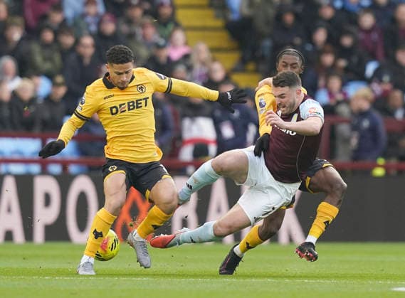 Birmingham, England, 30th November 2025. John McGinn of Aston Villa (c) fouled by Jackson Tchatchoua (l) and Jean-Ricner Bellegarde (r) of Wolverhampton Wanderers during the Aston Villa vs Wolverhampton Wanderers Premier League match at Villa Park, Birmingham. Picture credit should read: Andrew Yates Sportimage EDITORIAL USE ONLY. No use with unauthorised audio, video, data, fixture lists, club league logos or live services. Online in-match use limited to 120 images, no video emulation. No use in betting, games or single club league player publications. SPI_012_AY_Villa_Wolves SPI-4336-0012