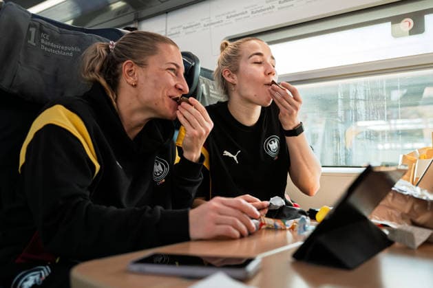 Handball, Frauen Deutschland - Bahnreise nach Dortmund Jenny Behrend (Deutschland) und Torhueterin Katharina Filter (Deutschland) essen Kindrüberaschungseier Stuttgart Baden-Württemberg Deutschland