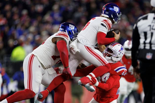 New York Giants safety Jevon Holland (C) is lifted off the ground as New England Patriots linebacker K Lavon Chaisson (R) attempts a sack during the first half at Gillette Stadium in Foxborough, Massachusetts on Monday, December 01, 2025.  BOP20251201026 CJxGUNTHER