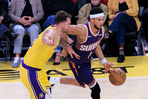 December 1, 2025, Los Angeles, California, USA: Devin Booker 1 of the Phoenix Suns drives past Luka Doncic 77 of the Los Angeles Lakers during their regular season NBA, Basketball Herren, USA game on Monday December 1, 2025 at Crypto.com Arena in Los Angeles, California. ARIANA RUIZ PI Los Angeles USA - ZUMAp124 20251201_zaa_p124_005 Copyright: xArianaxRuizx