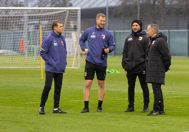 Manuel Baum (Trainer FC Augsburg, re.) im Gespräch mit Benedikt Brust (Spiel- und Videoanalyst FC Augsburg), Quirin Löppert (Reha- und Athletiktrainer FC Augsburg) und Fabio Leutenecker (Co.-Trainer FCA U 17); FC Augsburg, Erstes Training unter Manuel Baum,