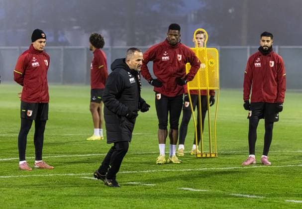 Manuel Baum (Trainer FC Augsburg) zeigt, wie es gehen soll, mit (v.li.) Fabian Rieder (FC Augsburg 32), Samuel Essende (FC Augsburg 9) und Elias Saad (FC Augsburg 26); FC Augsburg, Erstes Training unter Manuel Baum,