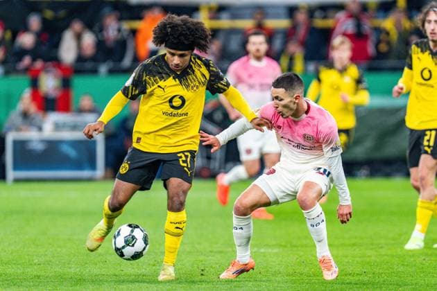 02.12.2025, Borussia Dortmund vs. Bayern 04 Leverkusen, DFB Pokal, Achtelfinale Karim Adeyemi (Borussia Dortmund, 27) Alejandro Grimaldo (Bayer 04 Leverkusen, 20) Wichtiger Hinweis: Gemaess den Vorgaben der DFL Deutsche Fussball Liga bzw. des DFB Deutscher Fussball-Bund ist es untersagt, in dem Stadion und oder vom Spiel angefertigte Fotoaufnahmen in Form von Sequenzbildern und oder videoaehnlichen Fotostrecken zu verwerten Copyright: xBahhoxKarax