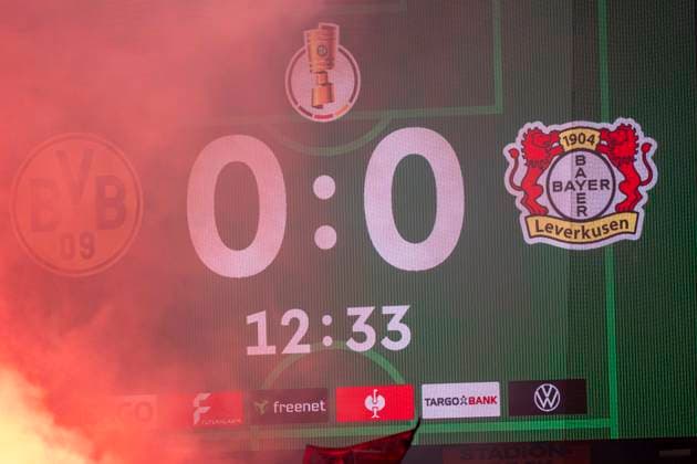 Gästefans mit Pyrotechnik. Fans von Bayer Leverkusen, im Hintergrund die Anzeigetafel mit der 12 Minute. Guest fans with pyrotechnics. Fans of Bayer Leverkusen, in the background the scoreboard with the 12 minute Borussia Dortmund - Bayer Leverkusen, DFB Pokal Achtelfinale (Round of 16) in Dortmund, Signal Iduna Park DFL regulations prohibit any use of photographs as image sequences and or quasi-video. Copyright: HMBxMedia xMarcoxBader