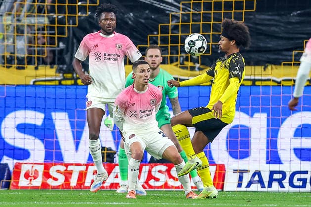 02.12.2025, Fußball, DFB-Pokal, Borussia Dortmund - Bayer 04 Leverkusen, Achtelfinale, Signal Iduna Park, Saison 2025 2026: Karim Adeyemi (BVB 27) im Zweikampf gegen Alejandro Grimaldo (Bayer04 20) vor dem tor von Torwart Mark Flekken (Bayer04 01) DFB regulations prohibit any use of photographs as image sequences and or quasi-video. Nordrhein-Westfalen Deutschland