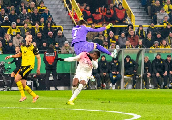 Zweikampf zwischen: duel between: Gregor KOBEL (Borussia Dortmund, 1) and Christian KOFANE (Bayer 04 Leverkusen, 35) Borussia Dortmund - Bayer Leverkusen, DFB Pokal Achtelfinale (Round of 16) in Dortmund, Signal Iduna Park DFL regulations prohibit any use of photographs as image sequences and or quasi-video. Copyright: HMBxMedia xMarcoxBader