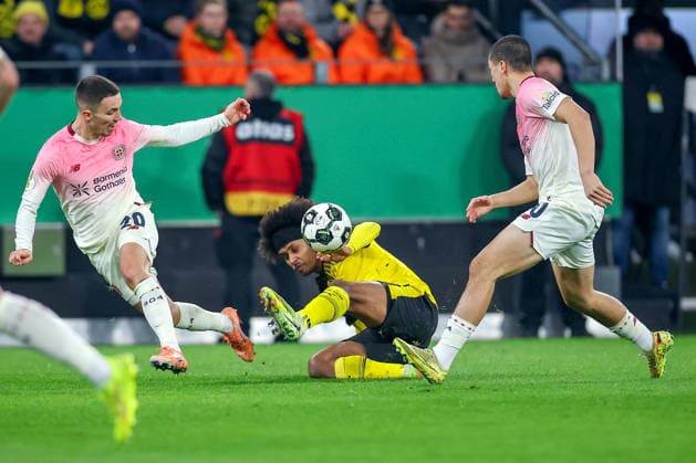 02.12.2025, Fußball, DFB-Pokal, Borussia Dortmund - Bayer 04 Leverkusen, Achtelfinale, Signal Iduna Park, Saison 2025 2026: Karim Adeyemi (BVB 27) im Zweikampf gegen Alejandro Grimaldo (Bayer04 20) und Ibrahim Maza (Bayer04 30) DFB regulations prohibit any use of photographs as image sequences and or quasi-video. Nordrhein-Westfalen Deutschland
