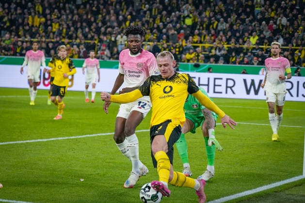 Deutschland: Fussball DFB-Pokal 2025 26, Achtelfinale - Borussia Dortmund vs Bayer 04 Leverkusen - Signal-Iduna-Park (Dortmund): Julian Ryerson (Borussia Dortmund, 26) Edmond Tapsoba (Bayer Leverkusen, 12) Mark Flekken (Bayer Leverkusen, 1) Copyright: xJOERANxSTEINSIEKx