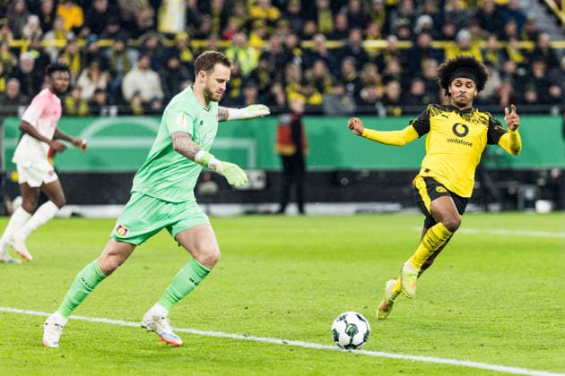 DORTMUND, GERMANY - DECEMBER 2: Karim Adeyemi (Borussia Dortmund, 27) tries to snatch the ball from Mark Flekken (Bayer 04 Leverkusen, 1) during the DFB Pokal Round of 16 match between Borussia Dortmund vs. Bayer 04 Leverkusen at Signal Iduna Park on Round of Sixteen of the DFB Pokal on December 2, 2025 in Dortmund, Germany. DFB REGULATIONS PROHIBIT ANY USE OF PHOTOGRAPHS AS IMAGE SEQUENCES AND OR QUASI-VIDEO. North Rhine Westphalia Germany Copyright: xBEAUTIFULxSPORTS Wunderlx
