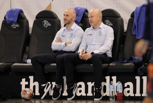 photo : smalltalk vor dem Anpfiff , Physiotherapeut Alain Carmand , links daneben Co-Trainer Baptiste Nicot Handball Herren am Di. 02.12.2025 Euroleague Mens EHF EURO LEAGUE , Tue. 02-12-25 THW Kiel - Montpellier HB