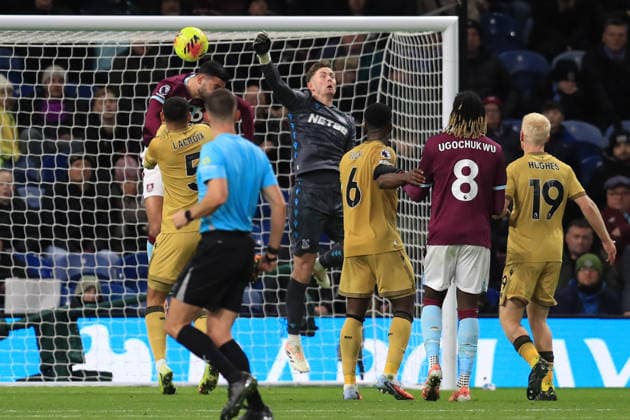 3rd December 2025; Turf Moor, Burnley, Lancashire, England; Premier League Football, Burnley versus Crystal Palace; Crystal Palace goalkeeper Dean Henderson punches the ball clear under pressure from Armando Broja of Burnley  DavidxBlunsden