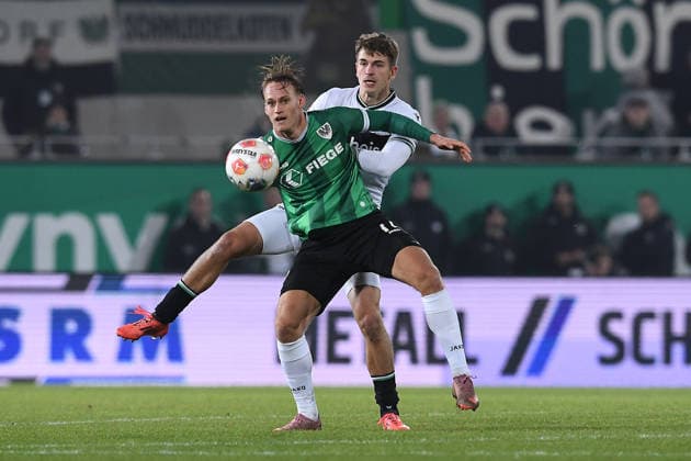 Fußball 2. Bundesliga 15. Spieltag SC Preußen Münster - Hannover 96 am 05.12.2025 im LVM-Preußenstadion in Münster Oscar Vilhelmsson ( Münster ), vorne - Maik Nawrocki ( Hannover ), hinten DFL regulations prohibit any use of photographs as image sequences and or quasi-video.